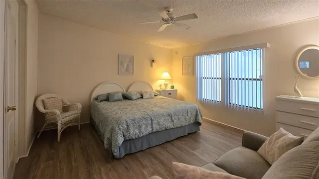a bedroom with a bed couch and windows