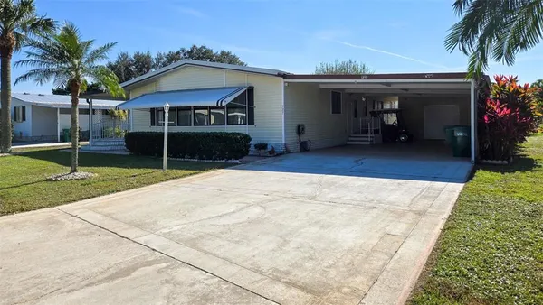 a view of a house with backyard and sitting area