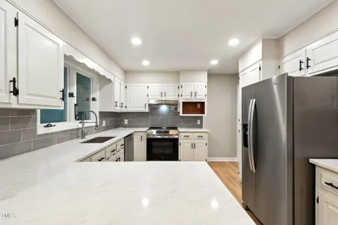 a kitchen with granite countertop a refrigerator and a sink