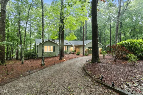 a view of a house with a backyard and tree