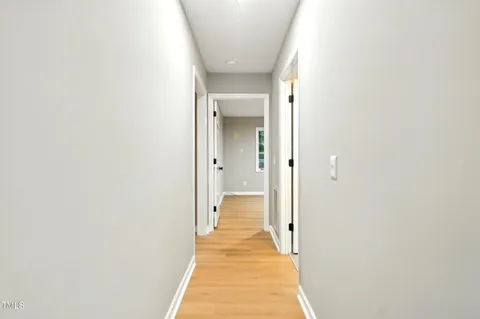 a view of a hallway with wooden floor