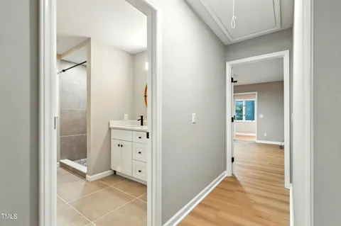a view of a hallway with closet and a bathroom