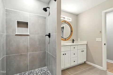 a bathroom with a granite countertop sink a mirror and a shower