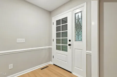 a view of an empty room with wooden floor and windows