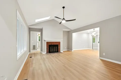 a view of empty room with wooden floor and fireplace