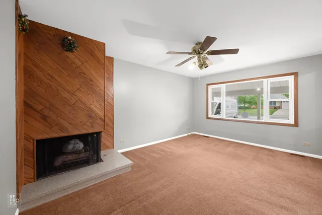 an empty room with windows and fireplace