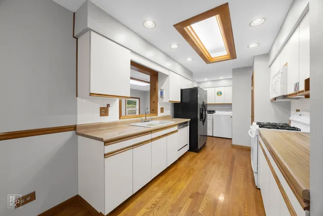 a large kitchen with kitchen island a large counter space a sink and stainless steel appliances