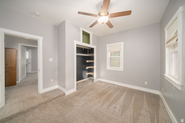 757 North 500 East Logan, UT 84321 - Photo 5 of 15 Unfurnished bedroom with light colored carpet, multiple windows, ceiling fan, and a closet