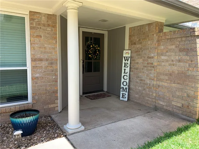 a view of a hallway with a chair and a potted plant