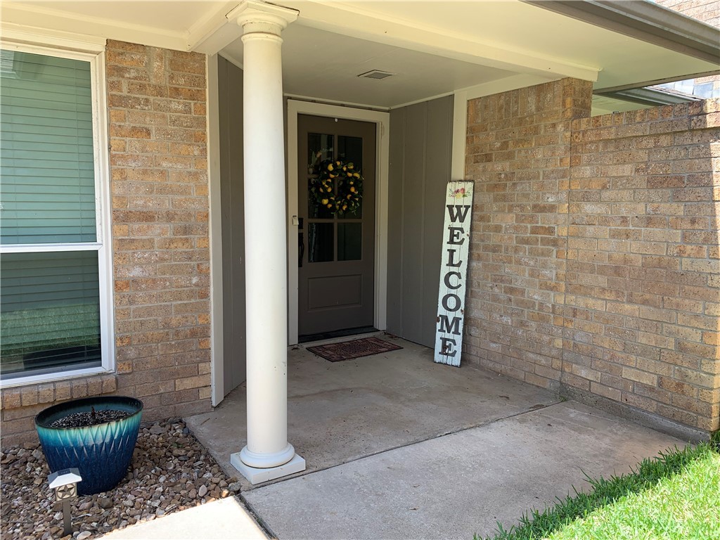 a view of a hallway with a chair and a potted plant