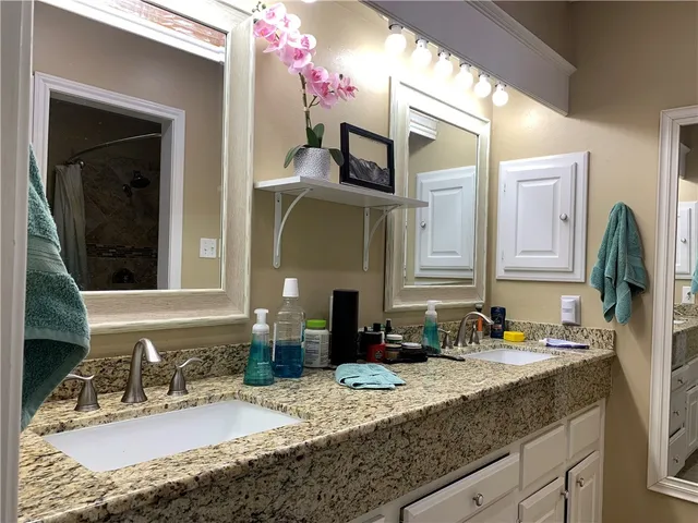 a bathroom with a granite countertop sink and a mirror