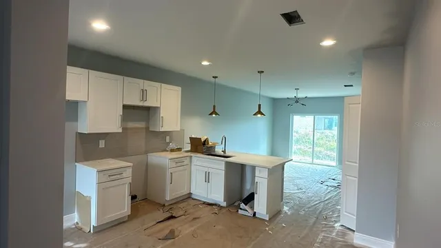 a kitchen with a sink a stove cabinets and stainless steel appliances