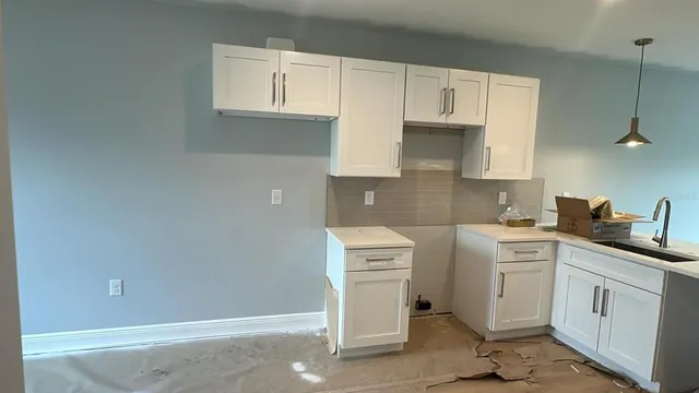 a kitchen with white cabinets and white appliances