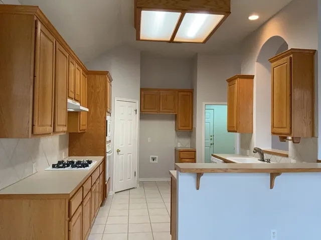a kitchen with a sink stove and cabinets