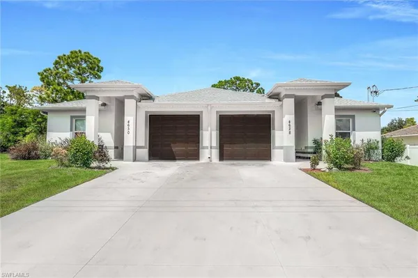 a front view of a house with a garden and yard