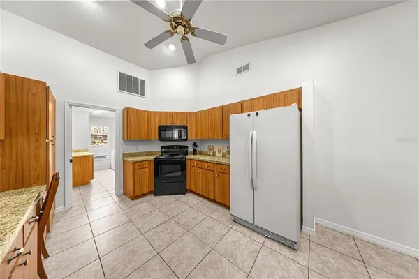 a large kitchen with stainless steel appliances granite countertop a sink stove and refrigerator