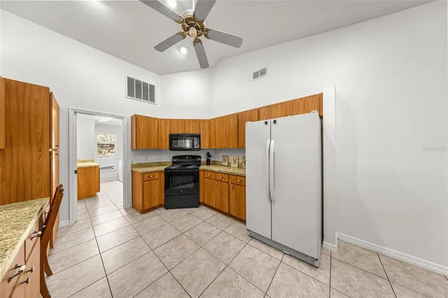 a large kitchen with stainless steel appliances granite countertop a sink stove and refrigerator