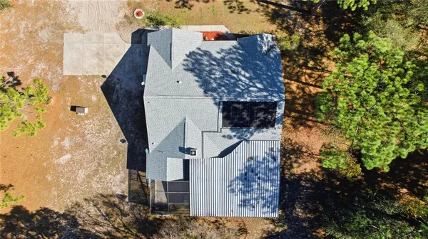 a aerial view of a house with a yard and large tree