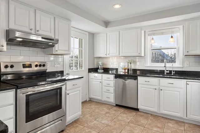 a kitchen with white cabinets stainless steel appliances and sink