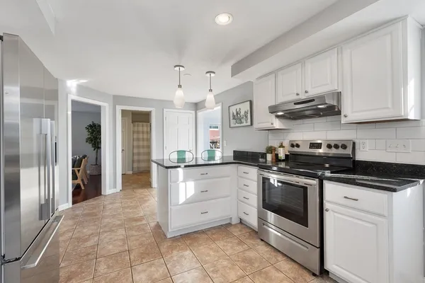 a kitchen with stainless steel appliances granite countertop a stove a sink and a refrigerator