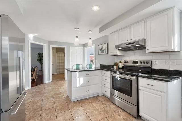 a kitchen with stainless steel appliances granite countertop a stove a sink and a refrigerator