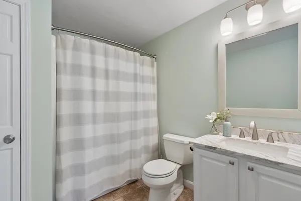a bathroom with a granite countertop sink a toilet and a mirror