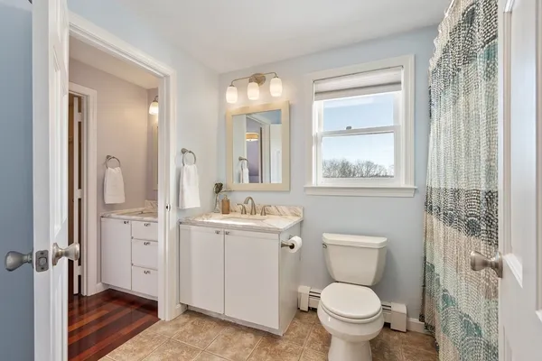 a bathroom with a toilet a sink and a window