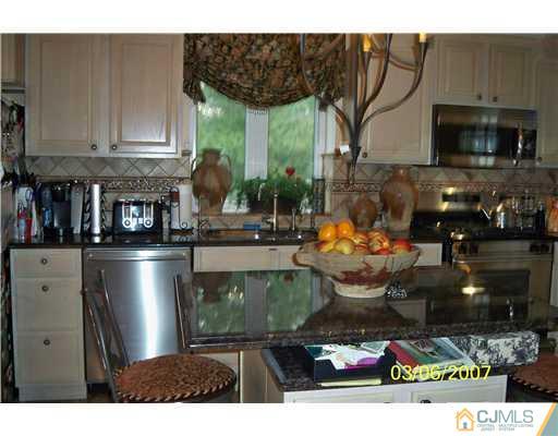 1669 Union Avenue, Unit NONE Hazlet, NJ 07730 - Photo 4 of 10 a kitchen with a stove a microwave and cabinets
