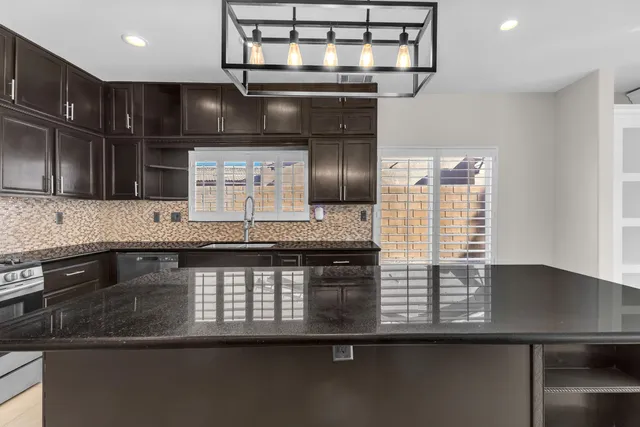 a kitchen with stainless steel appliances granite countertop a sink stove and microwave