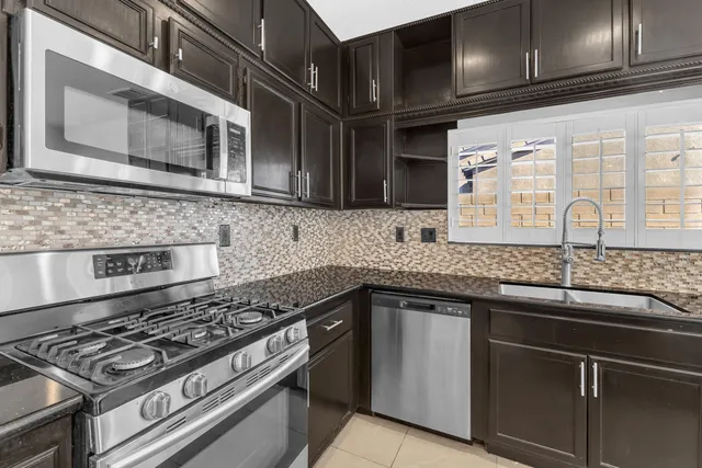 a kitchen with granite countertop cabinets stainless steel appliances and a sink
