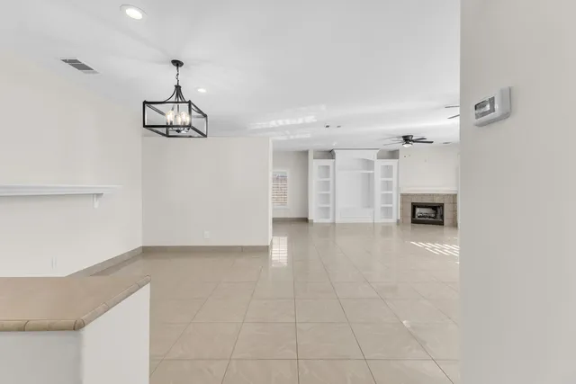 a view of a hallway with wooden floor and a kitchen