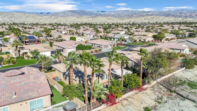 an aerial view of residential houses with outdoor space and ocean view