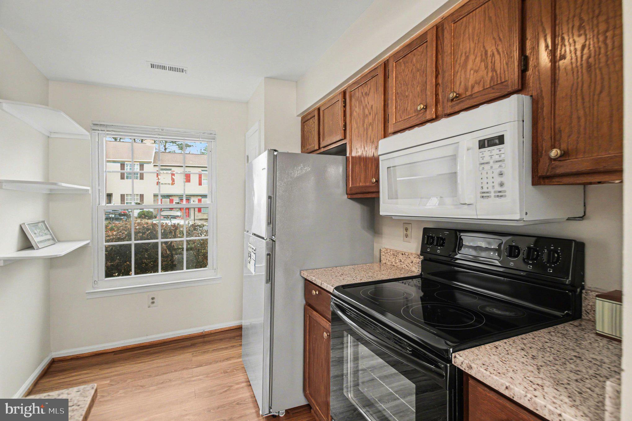 211 Wind Ridge Drive Stafford, VA 22554 - Photo 4 of 27 a kitchen with stainless steel appliances granite countertop a stove a refrigerator and a microwave