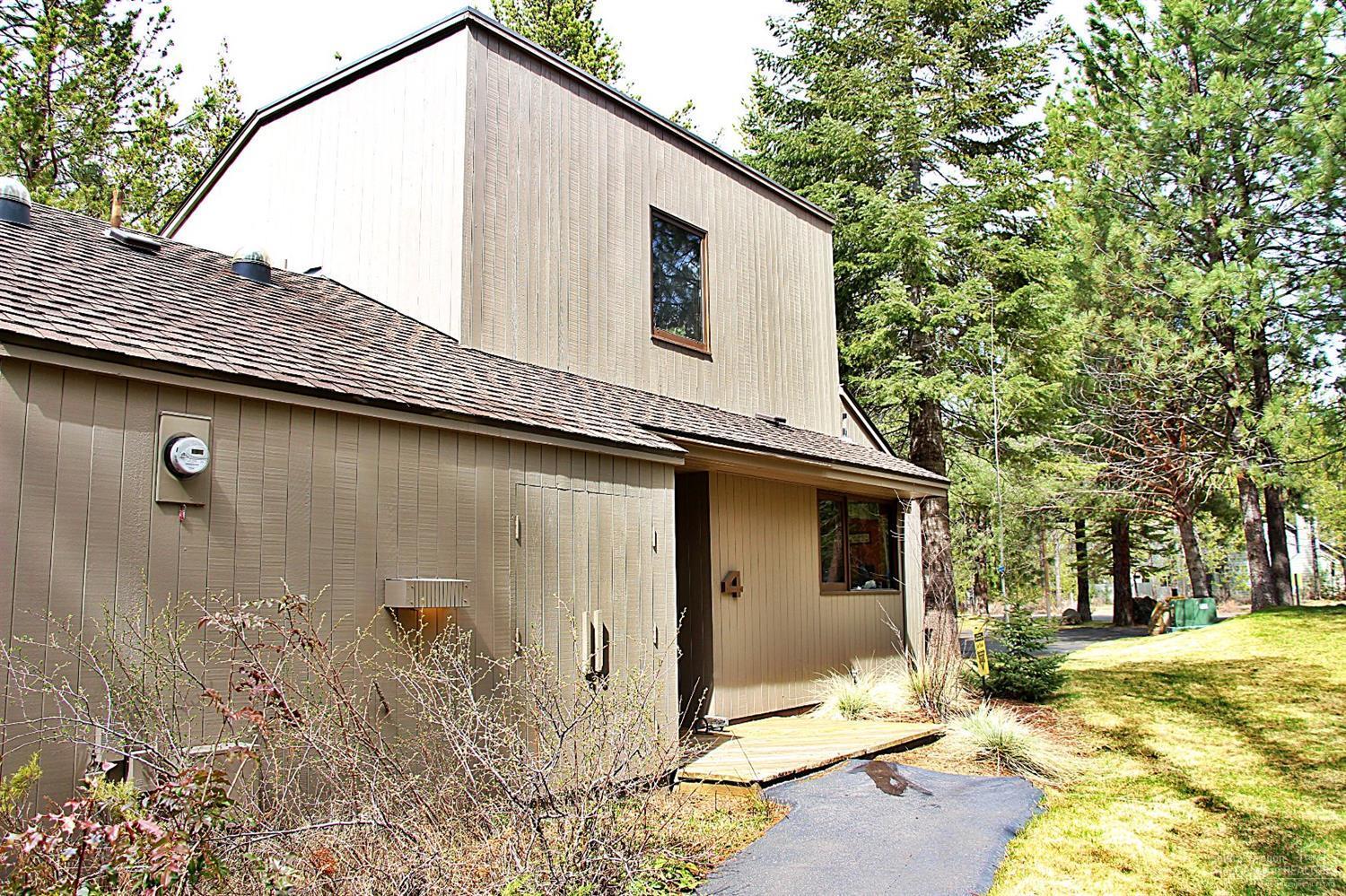 4 Meadow House Loop Sunriver, OR 97707 - Photo 1 of 17 a backyard of a house with large trees and outdoor seating