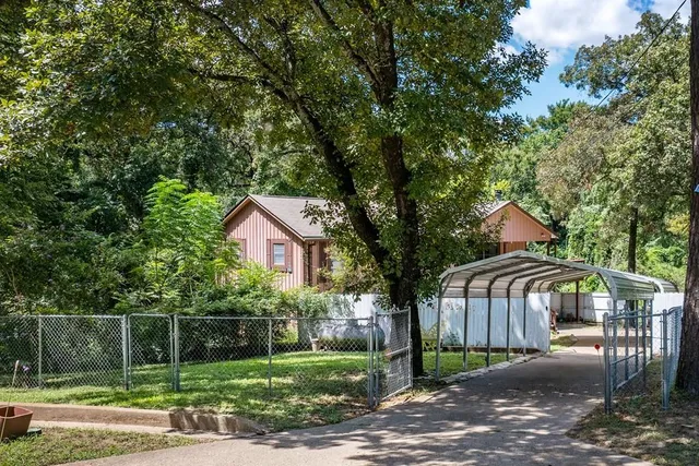 a view of a house with backyard and trees