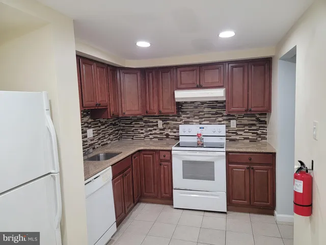 a kitchen with a stove sink and cabinets