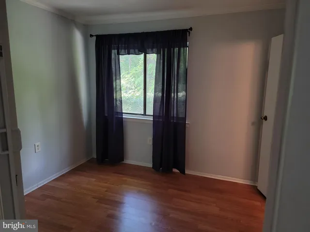 an empty room with wooden floor and a window