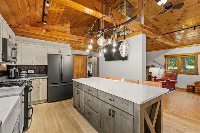 a kitchen with a refrigerator a sink dishwasher and a stove with wooden floor