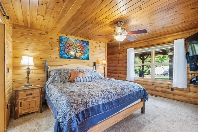 a bedroom with a bed and a large window with the outer view