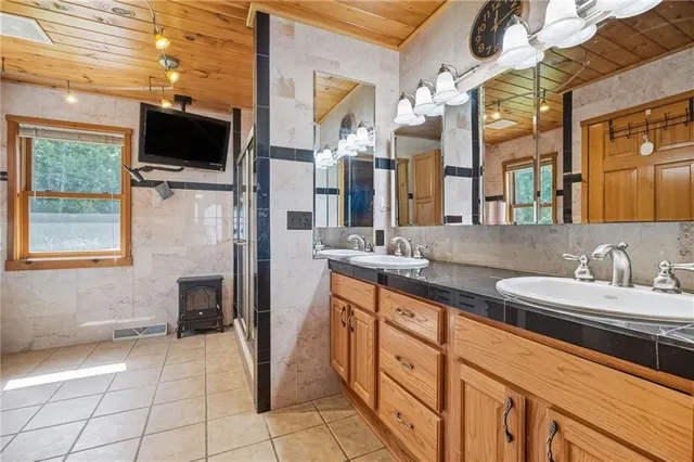 a bathroom with a granite countertop sink a large mirror and a bathtub