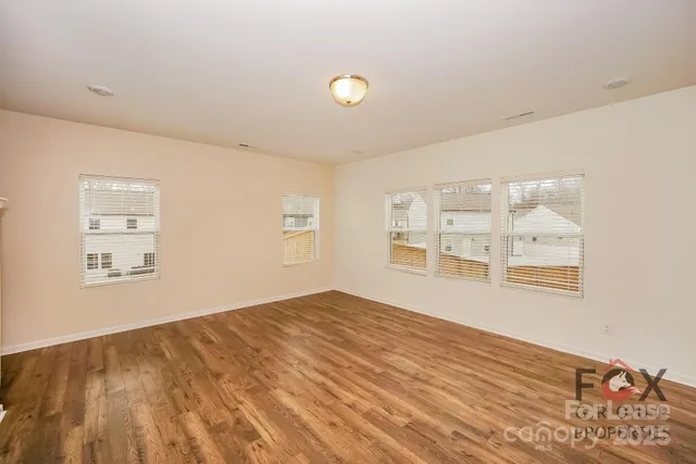 a view of a living room with kitchen island stainless steel appliances wooden floor and view living room
