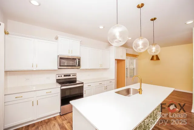 a kitchen with stainless steel appliances granite countertop a sink a stove and a refrigerator