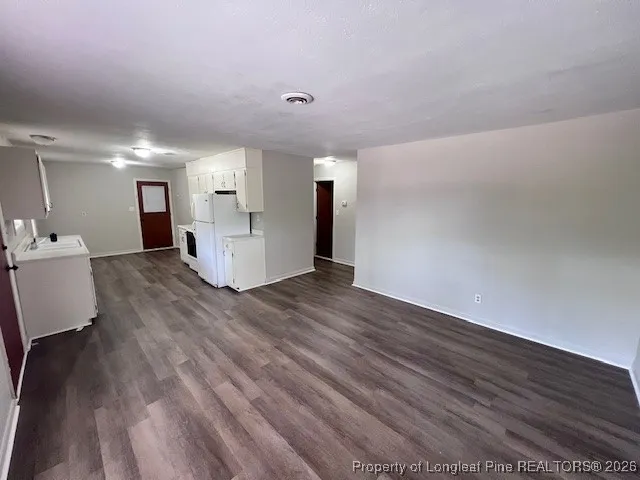 a kitchen with white cabinets and white appliances
