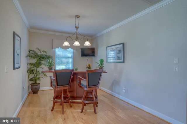 a living room with furniture kitchen view and a wooden floor