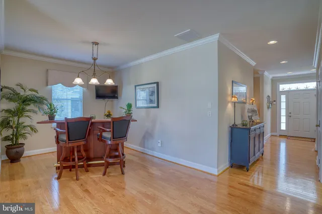 a kitchen with stainless steel appliances granite countertop wooden floor dining table and chairs