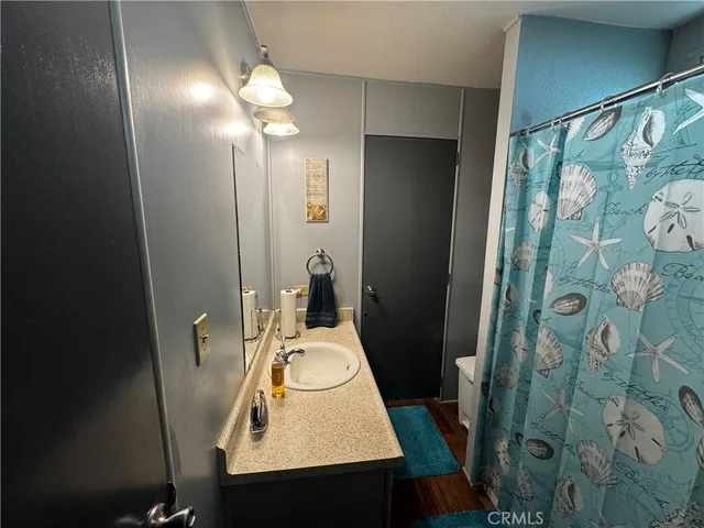 a bathroom with a sink and mirror with shower