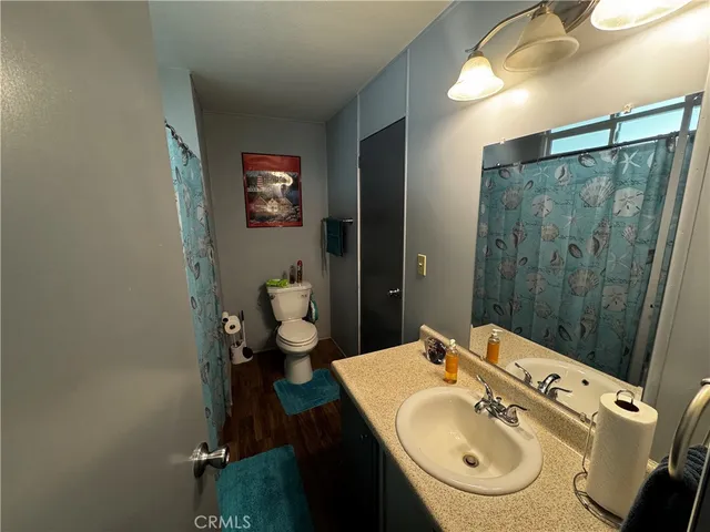 a bathroom with a sink and mirror with toilet