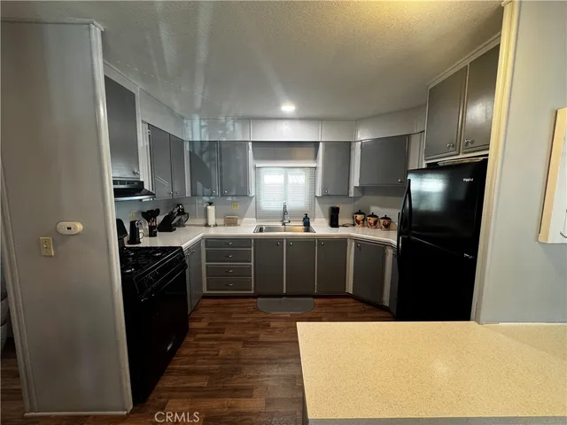 a kitchen with stainless steel appliances kitchen island granite countertop a refrigerator a sink a stove and oven