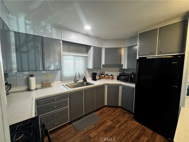 a kitchen with a sink a refrigerator and cabinets