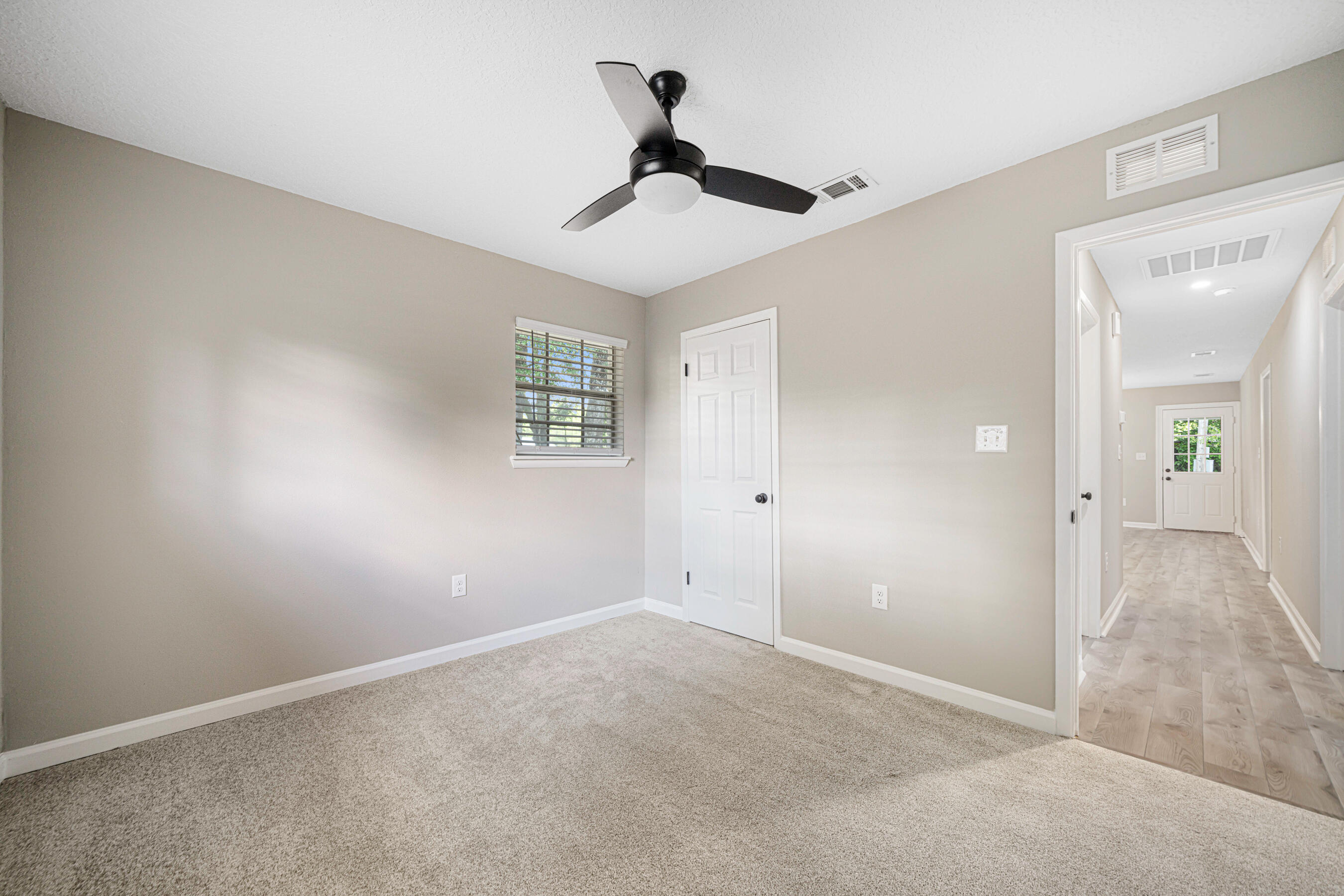 207 Oglesby Avenue Crestview, FL 32536 - Photo 22 of 30 an empty room with chandelier fan and windows